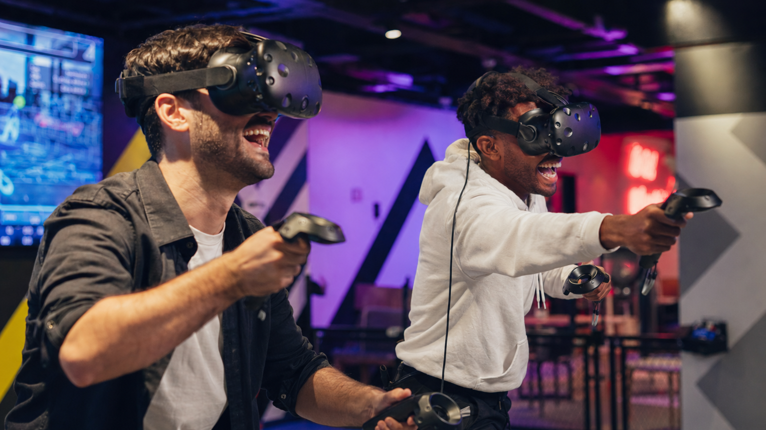 Two friends playing VR games together in a VR arcade